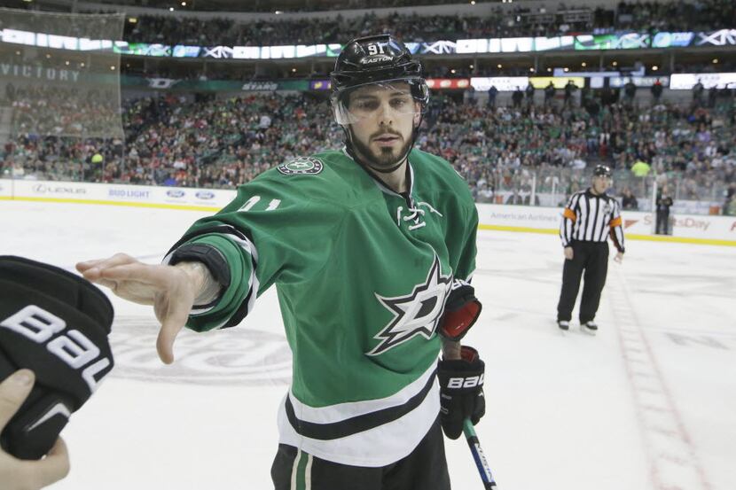 Dallas Stars center Tyler Seguin (91) reaches out for glove from the bench during the first...