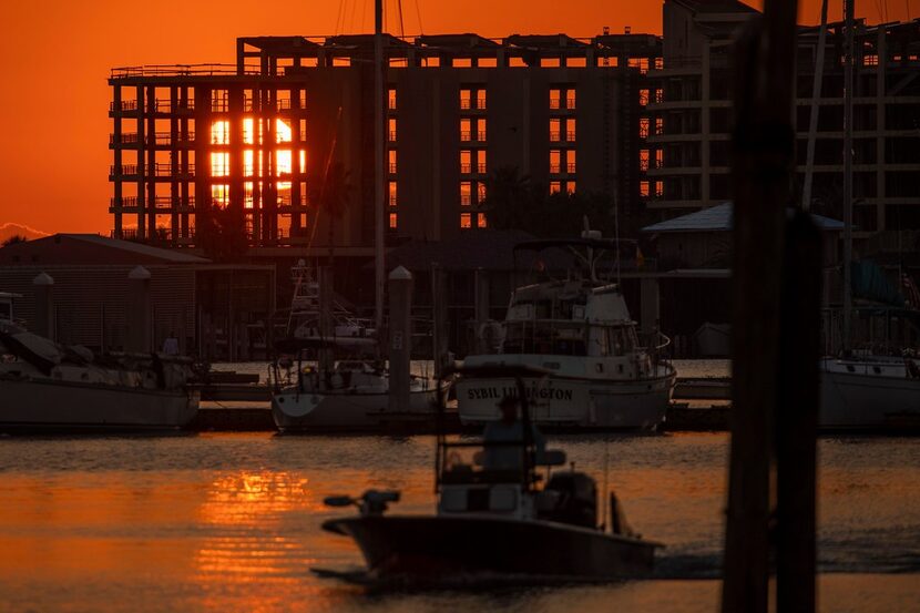 The rising sun shines through the skeletal remains of the Clines Landing condominium tower...