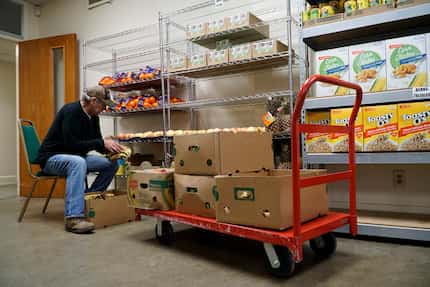 Mark Blaker stocks the food pantry at Mission Oak Cliff in Dallas on Tuesday,  Dec. 10, 2019.