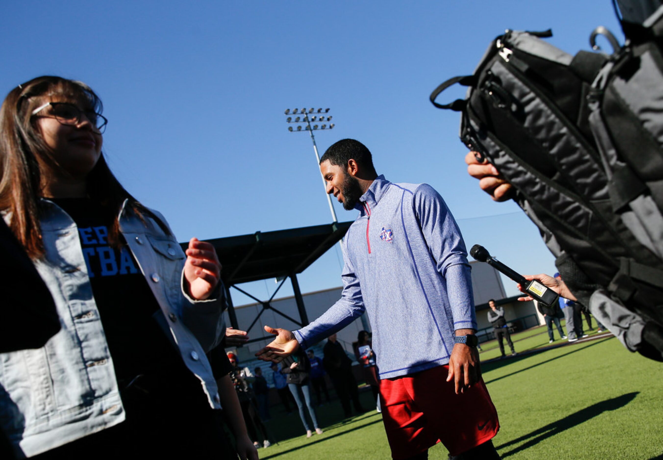 Rangers shortstop Elvis Andrus, center, donates baseball and softball equipment to Thomas...