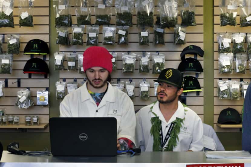 Employees David Marlow, right, and Chris Broussard work behind sales counter inside Medicine...
