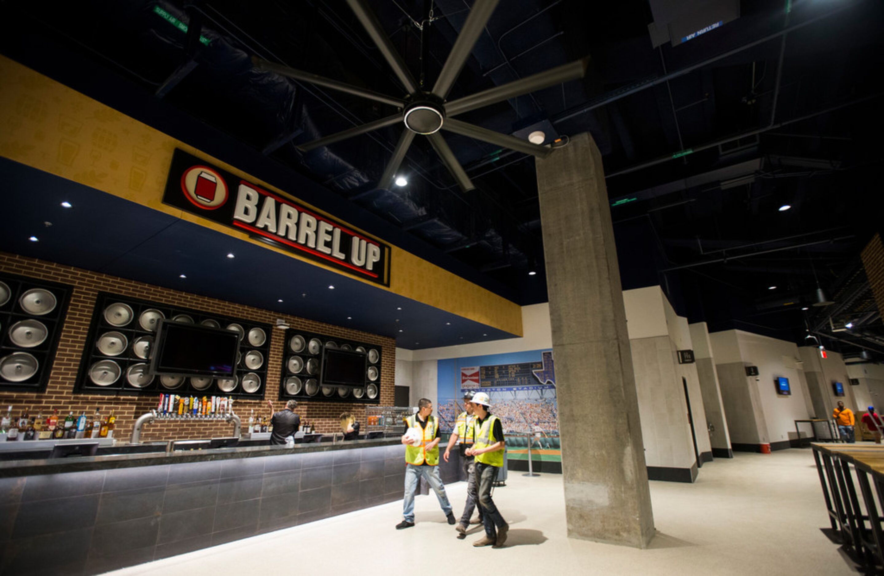 Workers walk past Barrel Up, a concession stand on the lower concourse, during an open house...