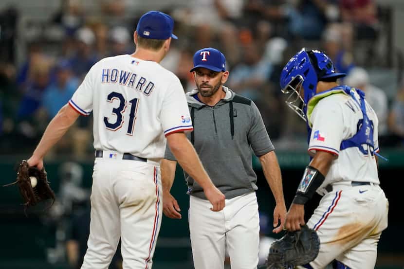 Texas Rangers starting pitcher Spencer Howard (31) talks with manager Chris Woodward,...