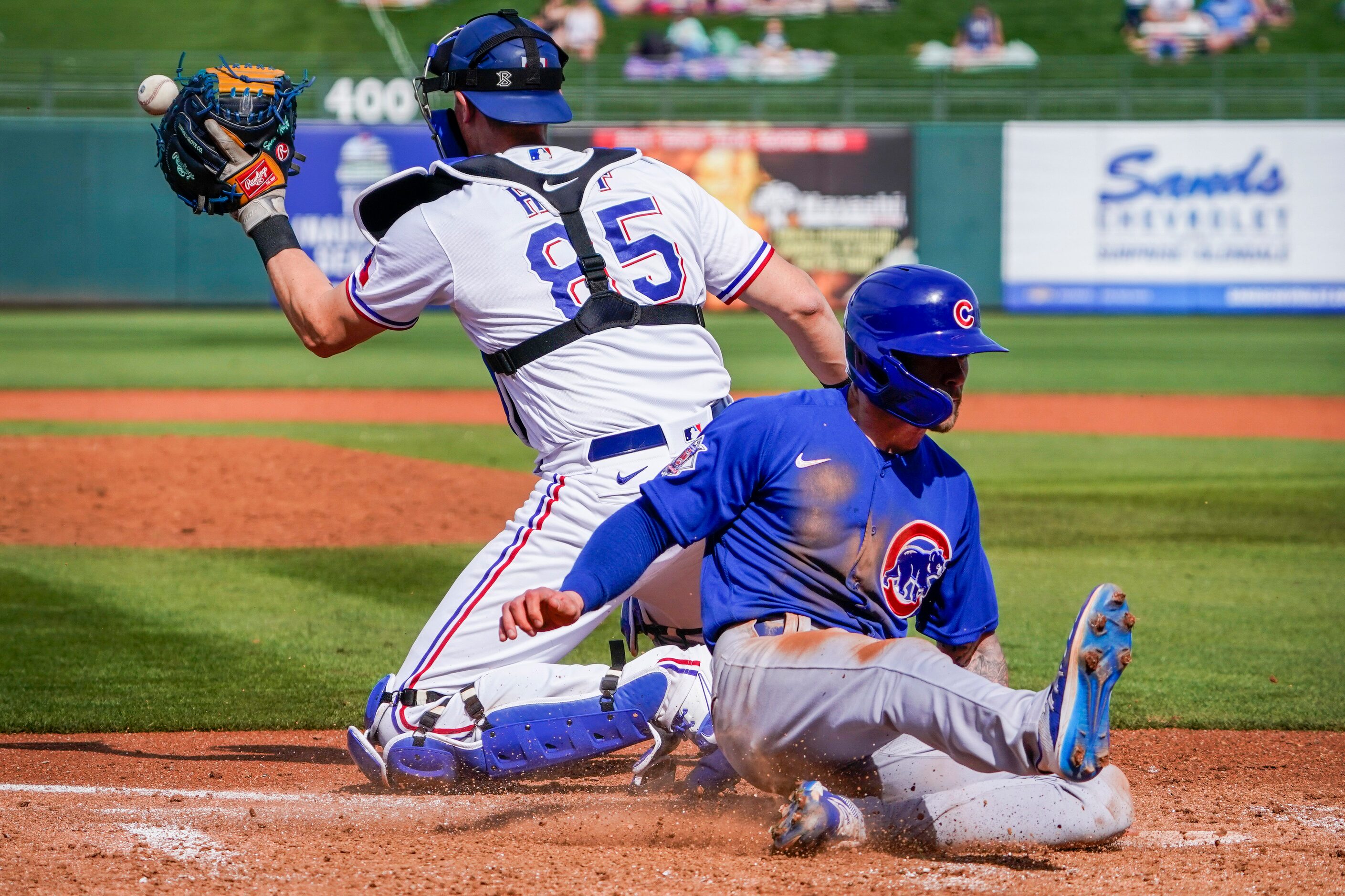 Chicago Cubs outfielder Ian Miller scores ahead of the throw to Texas Rangers catcher Sam...