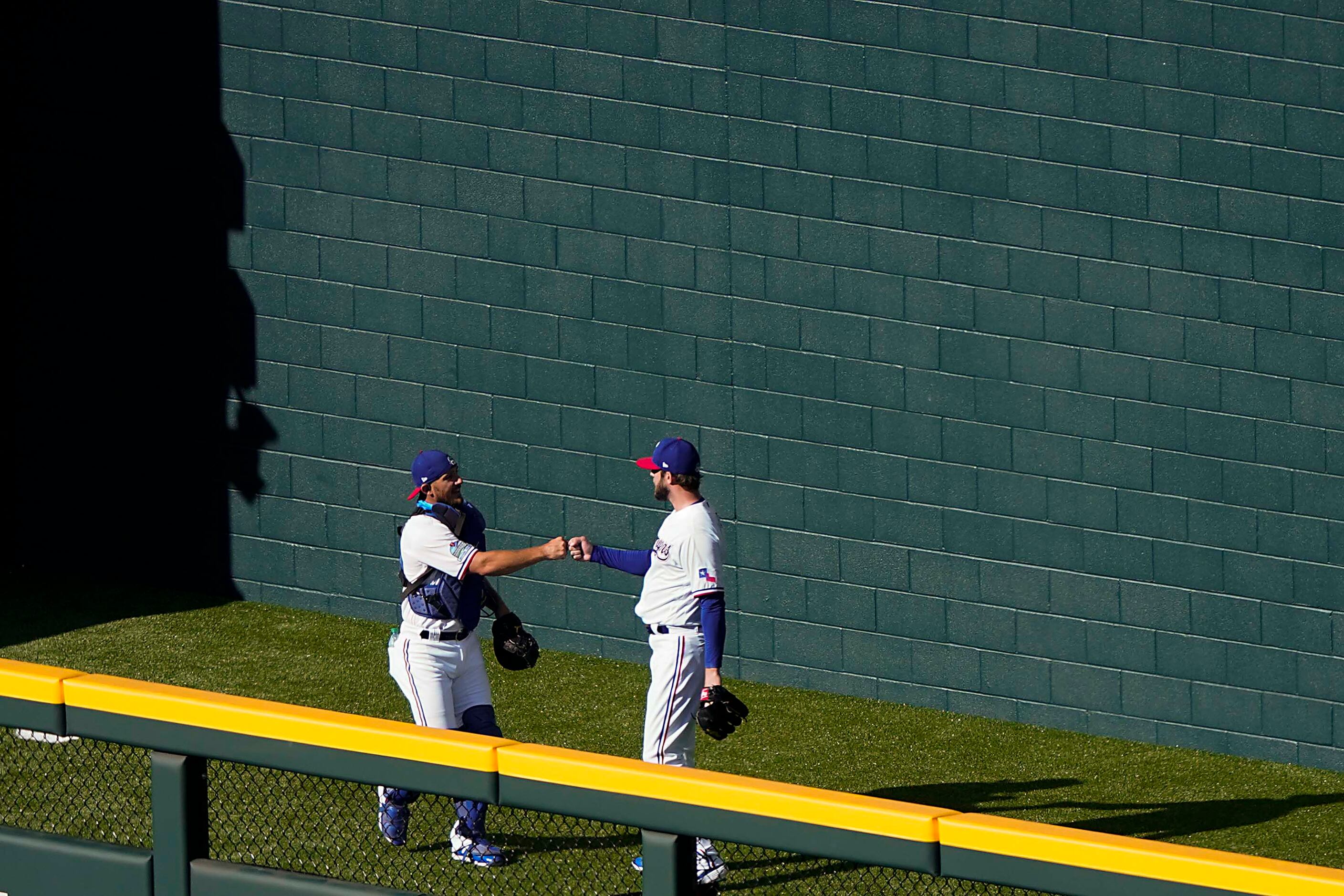 Pitcher Jordan Lyles fist bumps catcher Jeff Mathis in the bullpen before an intrasquad game...