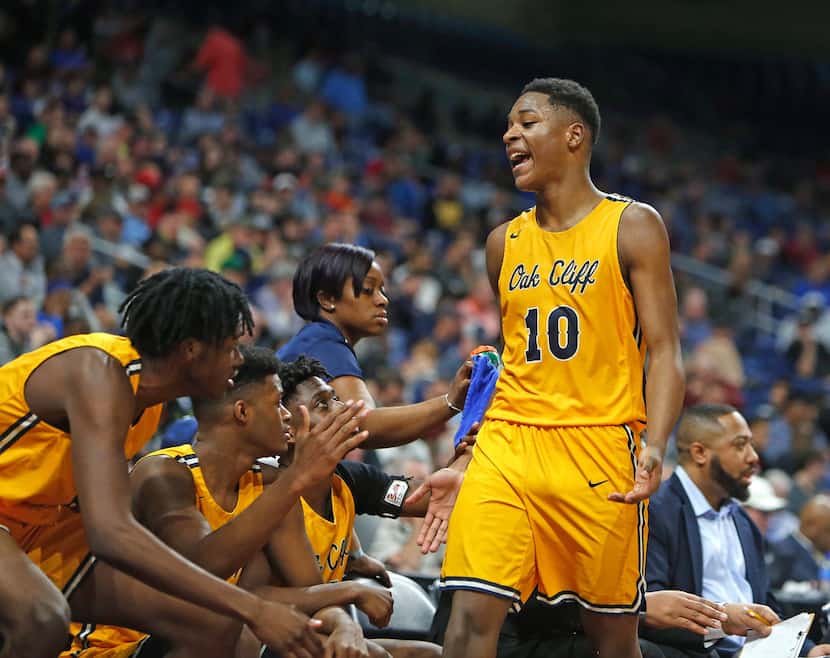 Oak Cliff Faith Academy's Trae Clayton #10 celebrates as he comes to the bench late in the...