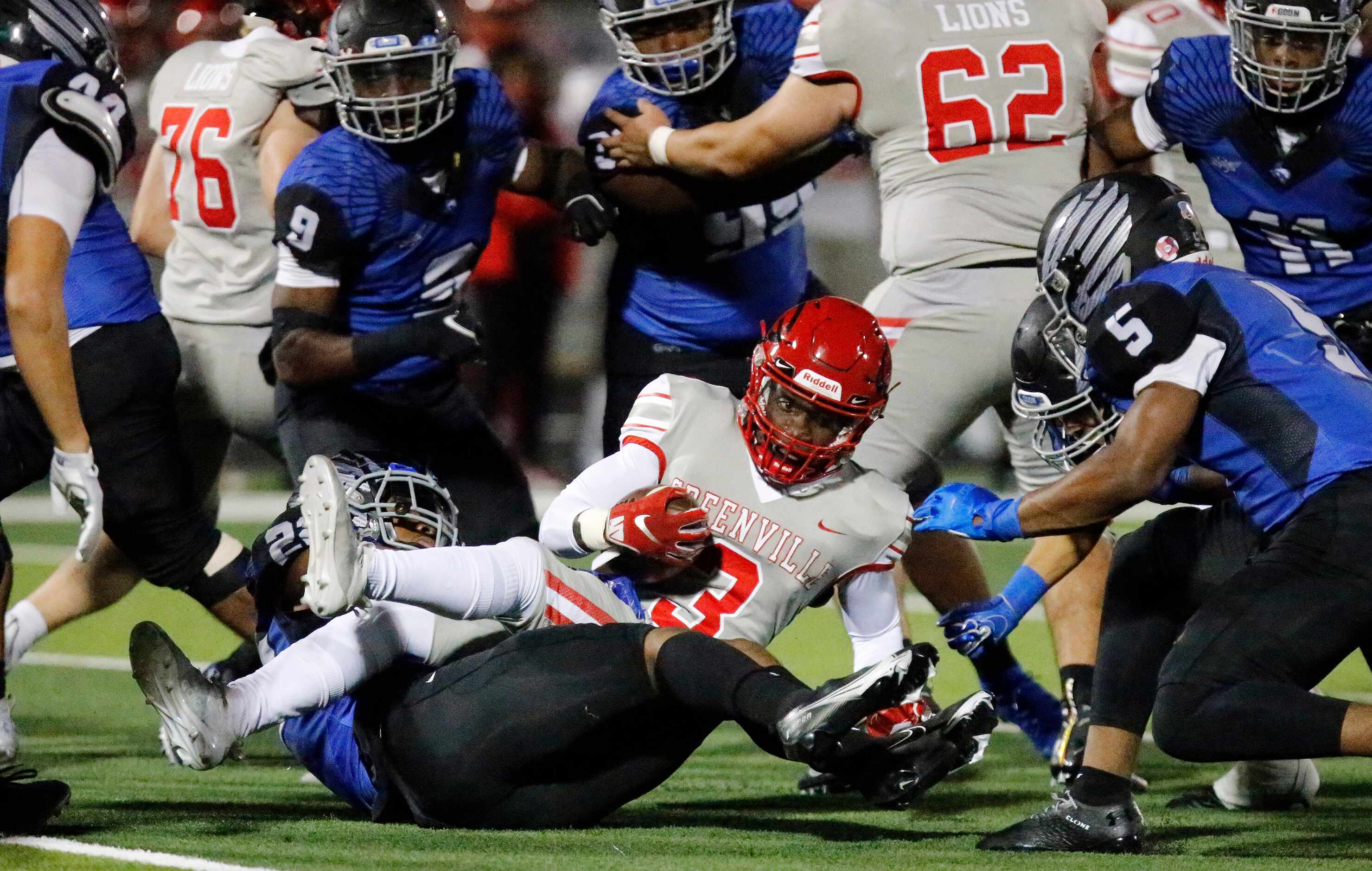 Greenville High School quarterback Miles Denson (3) is tackled during the first half as...