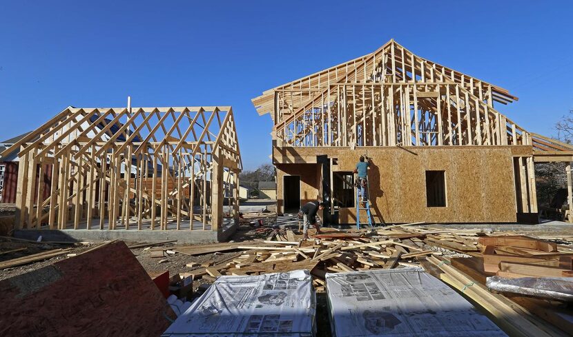 Workers Steven Garcia  and Antonio Camacho work on a house in the 1600 block of Kings...