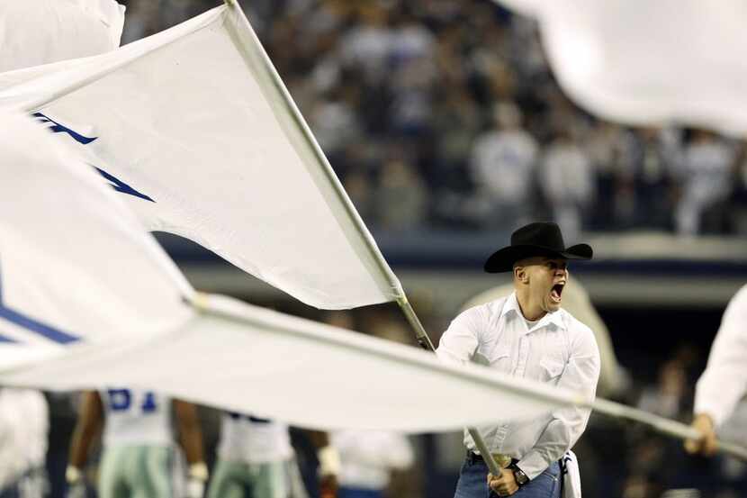 Dallas Cowboys flag person yells as the team is announced prior to the start of a game...