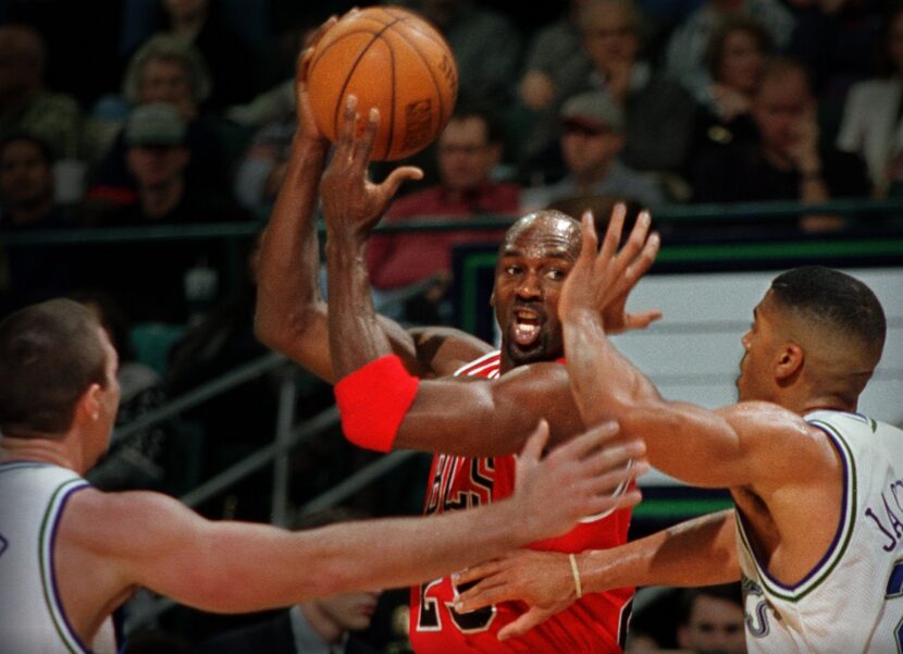 Chicago's Michael Jordan (middle) is pressured  by Dallas Mavericks Loren Meyer (left) and...