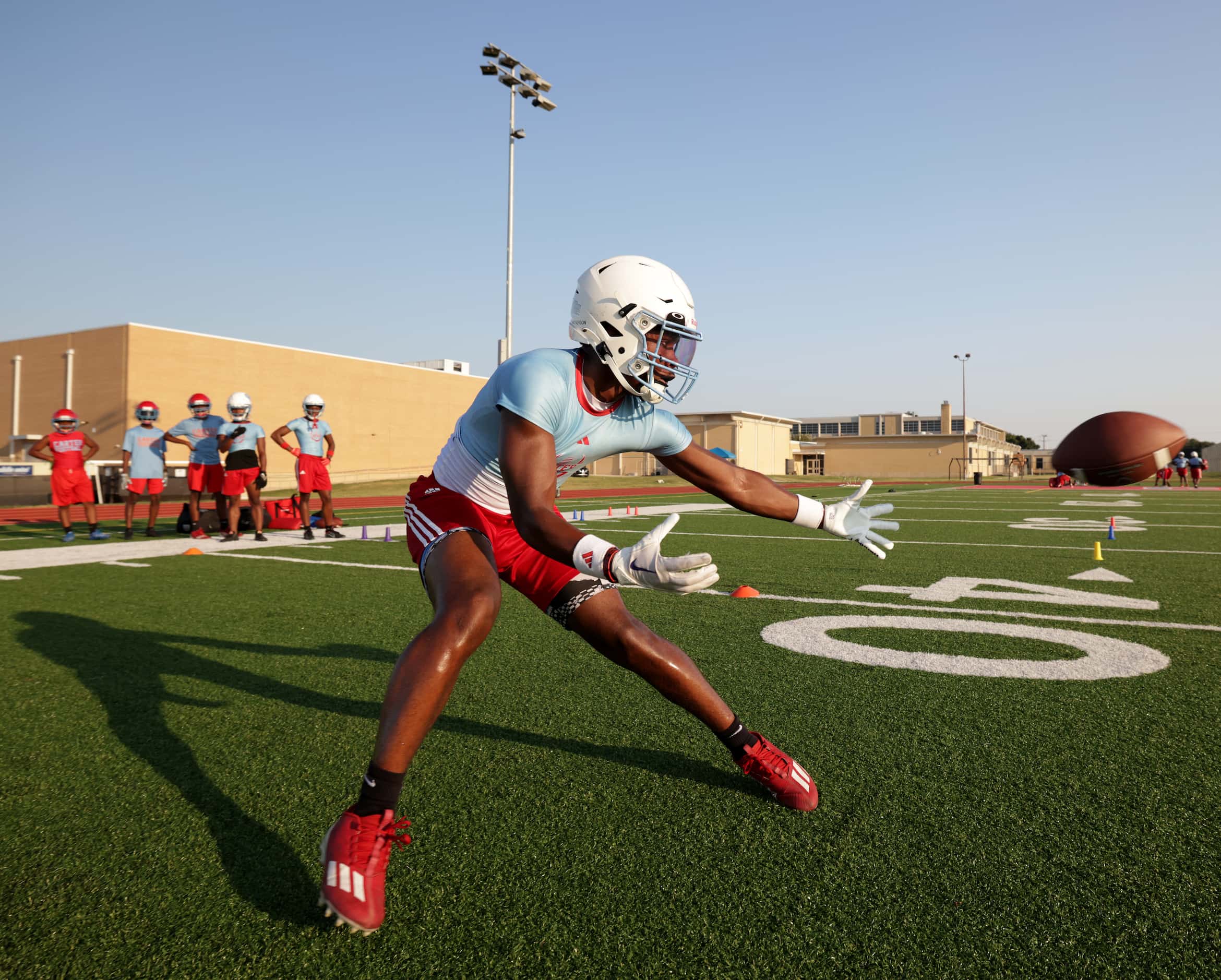 Camden Patterson catches the ball as players attend their first day of football practice at...