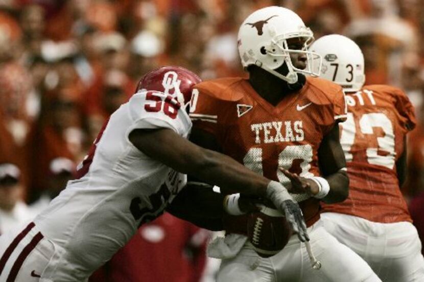 Texas' quarterback Vince Young has the ball knocked from his hand by OU's Calvin Thibodeaux...