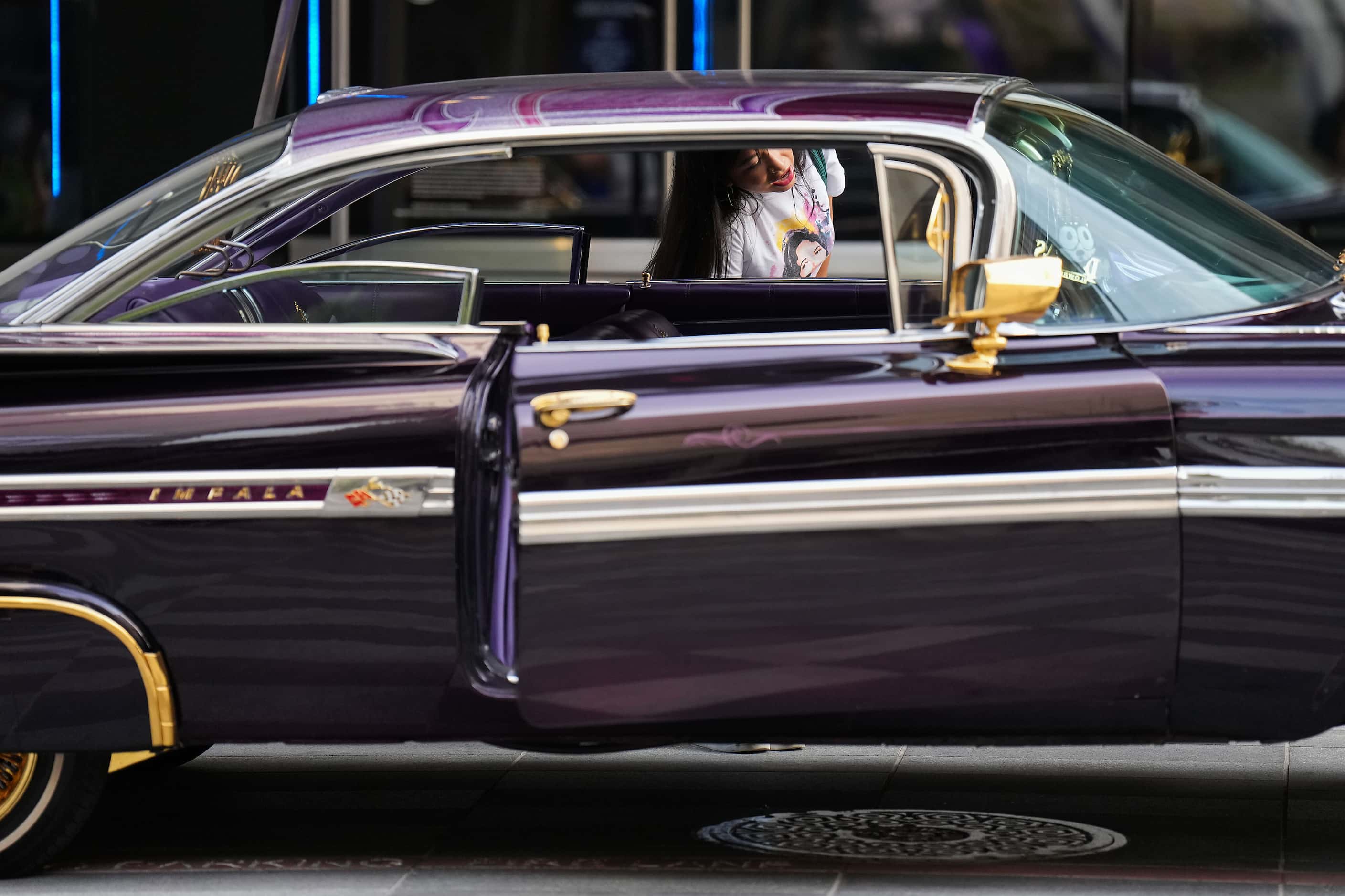 A woman checks out  a display of low riders during a celebration of the life of singer...