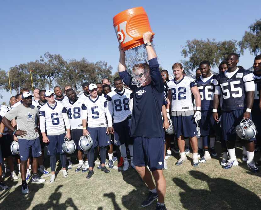 Cowboys head coach Jason Garrett pours ice water on his head after an afternoon practice in...