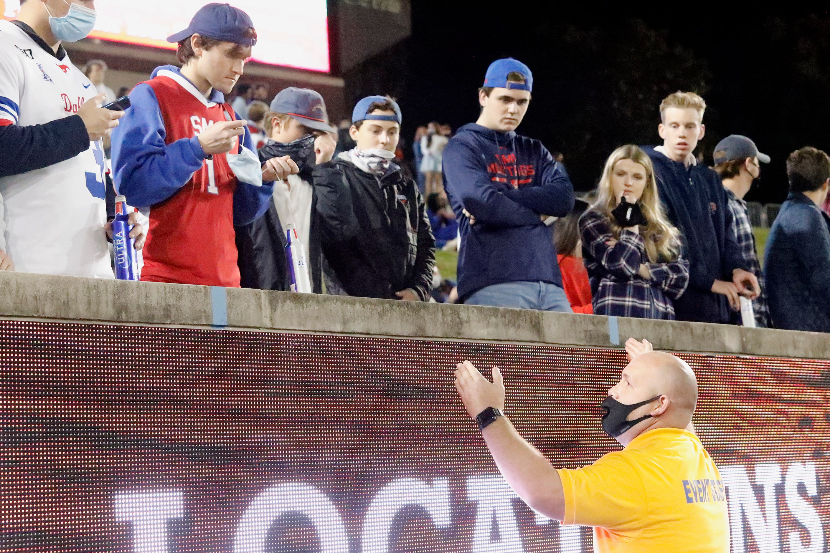 A stadium security member warns the student section to social distance during the first half...