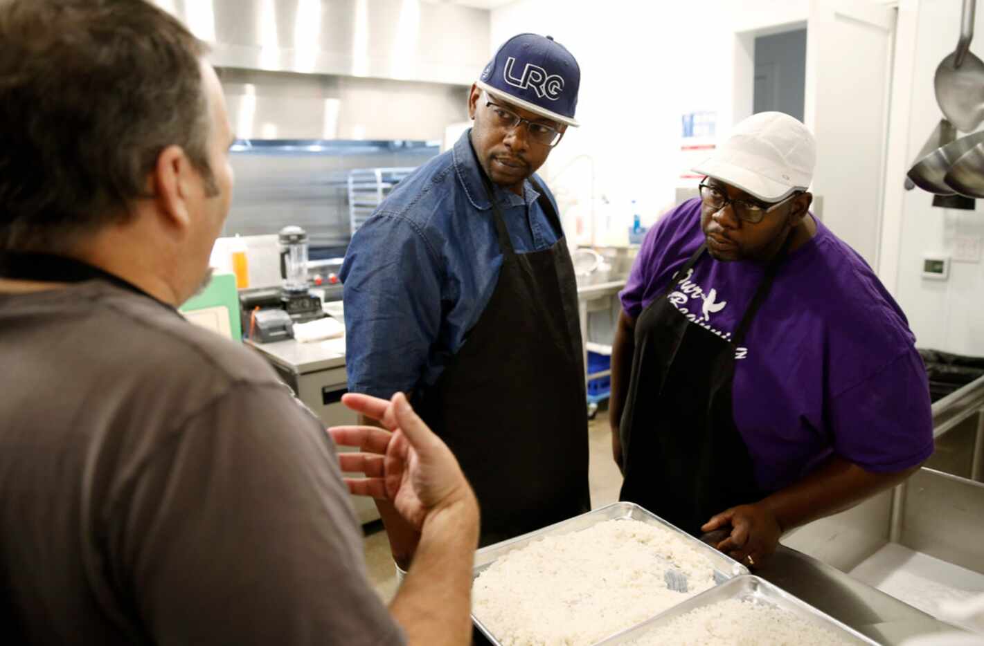 Chef Mike Noyes, left, talks to Derrick Runnels, center, and brother Darrell Runnels about...