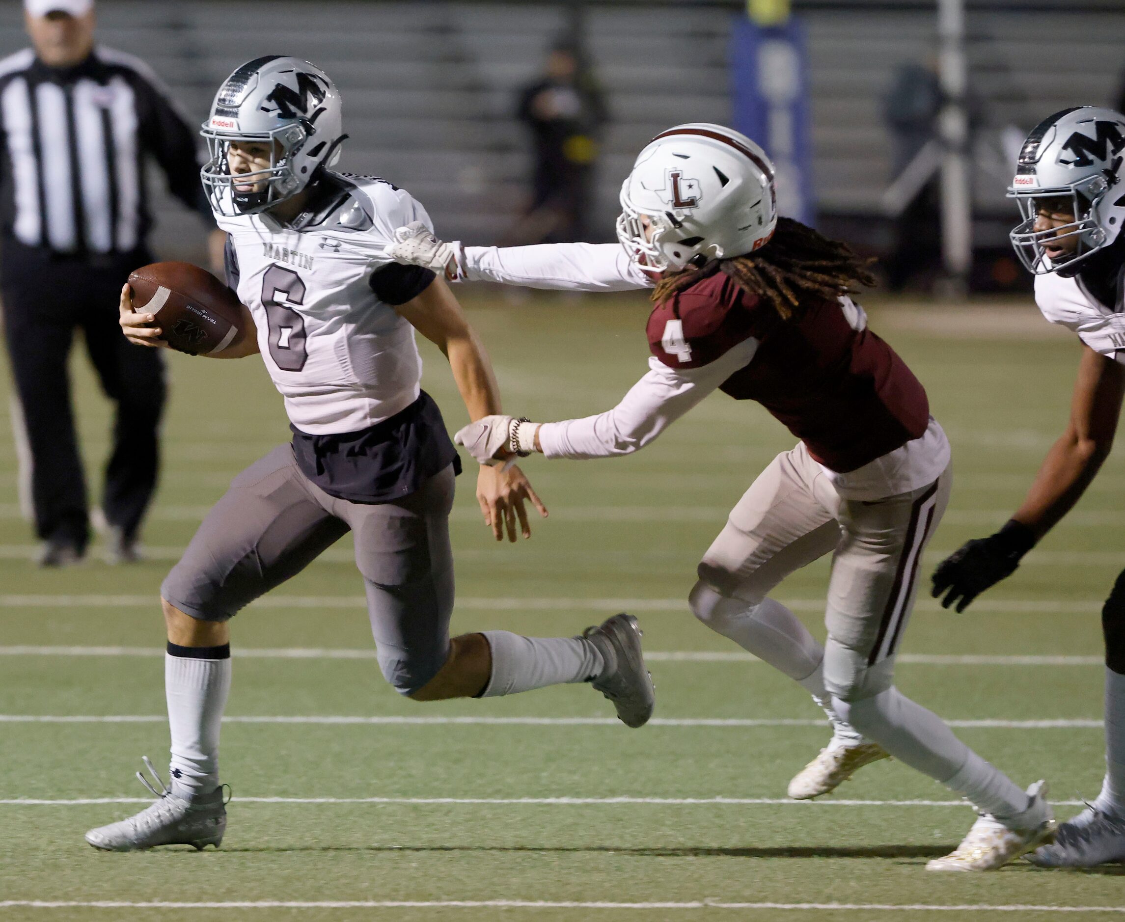 Martin quarterback Zach Mundell (6) tries to get past Lewisville’s Kamon Dewberry (4) during...