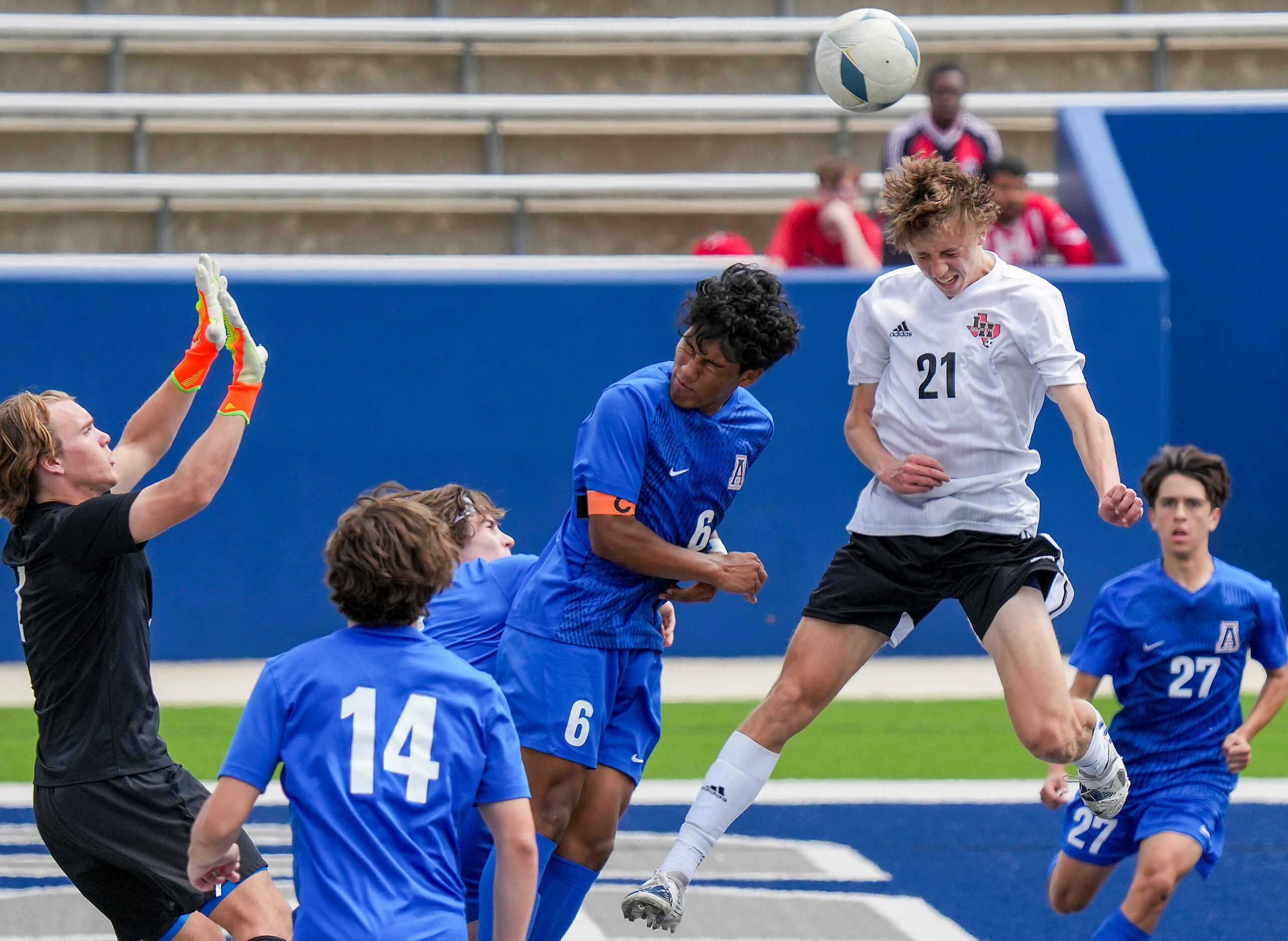 Lake Highlands midfielder James Boone (21) wins a header against Allen defender Ryoma Colyar...