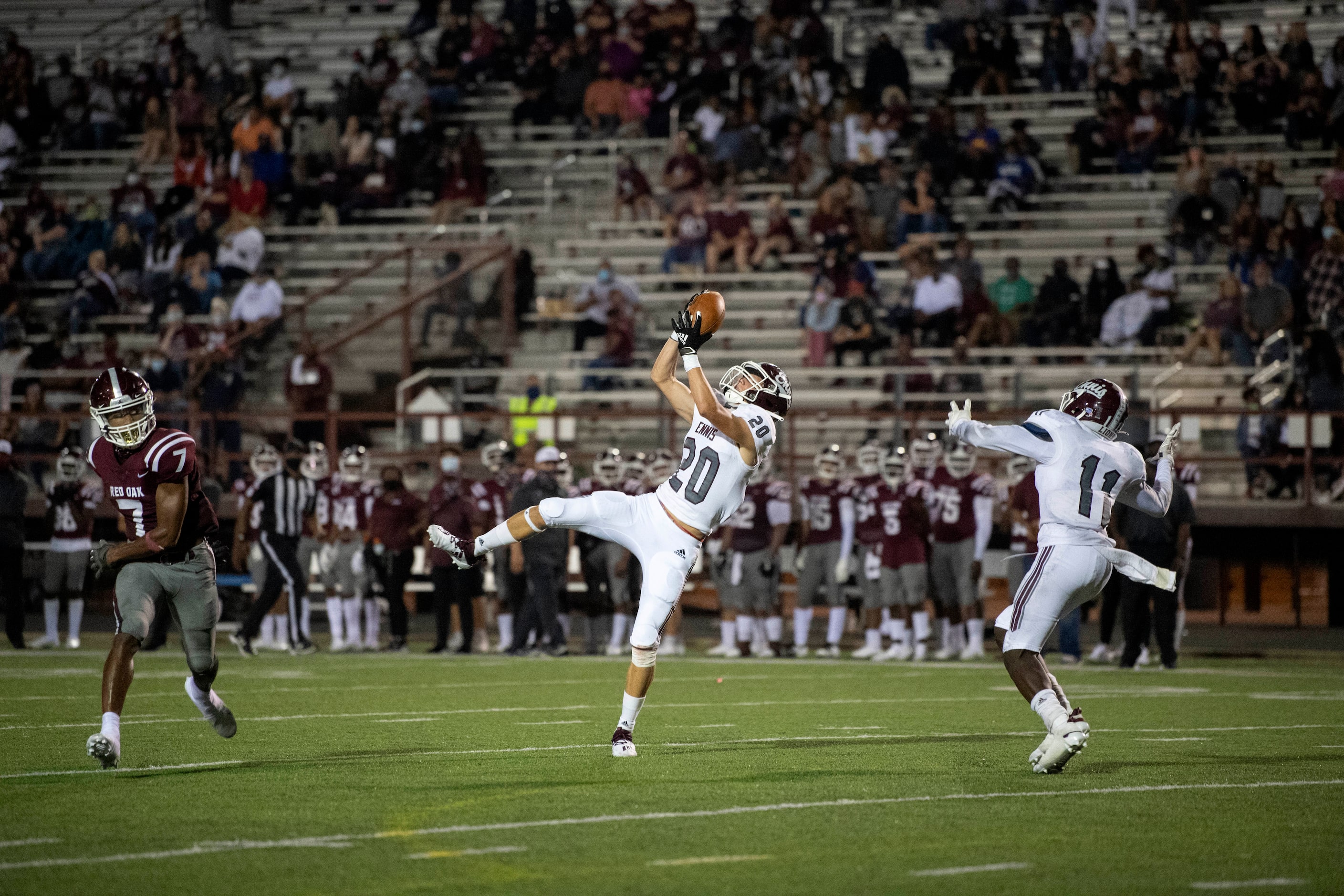 Ennis junior defensive back Ashton Ehly (20) pulls in an interception in front of senior...