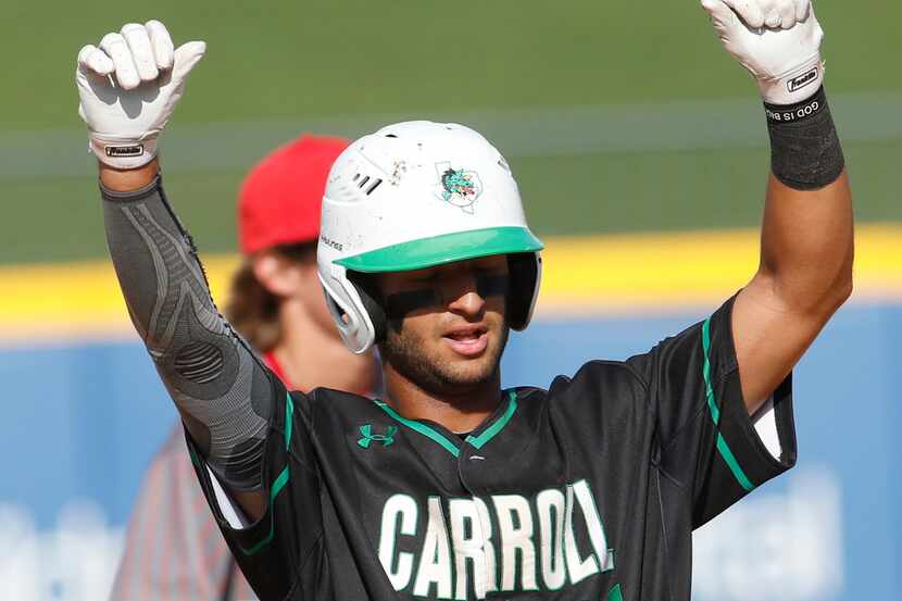 Southlake Carroll shortstop Jorge Figueroa (24) acknowledges the roar from the dugout and...