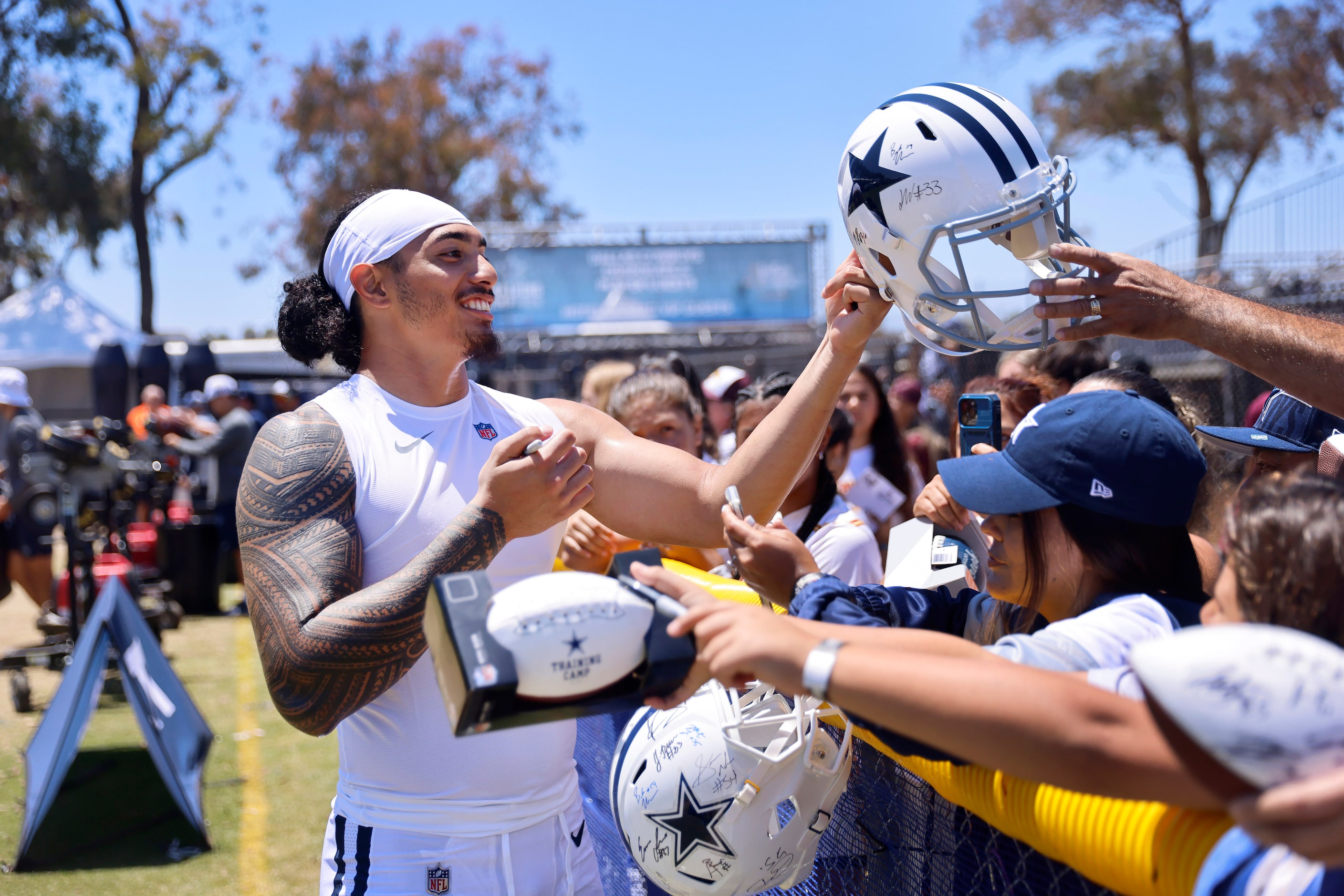 Dallas Cowboys rookie linebacker Marist Liufau signs autographs for fans following training...