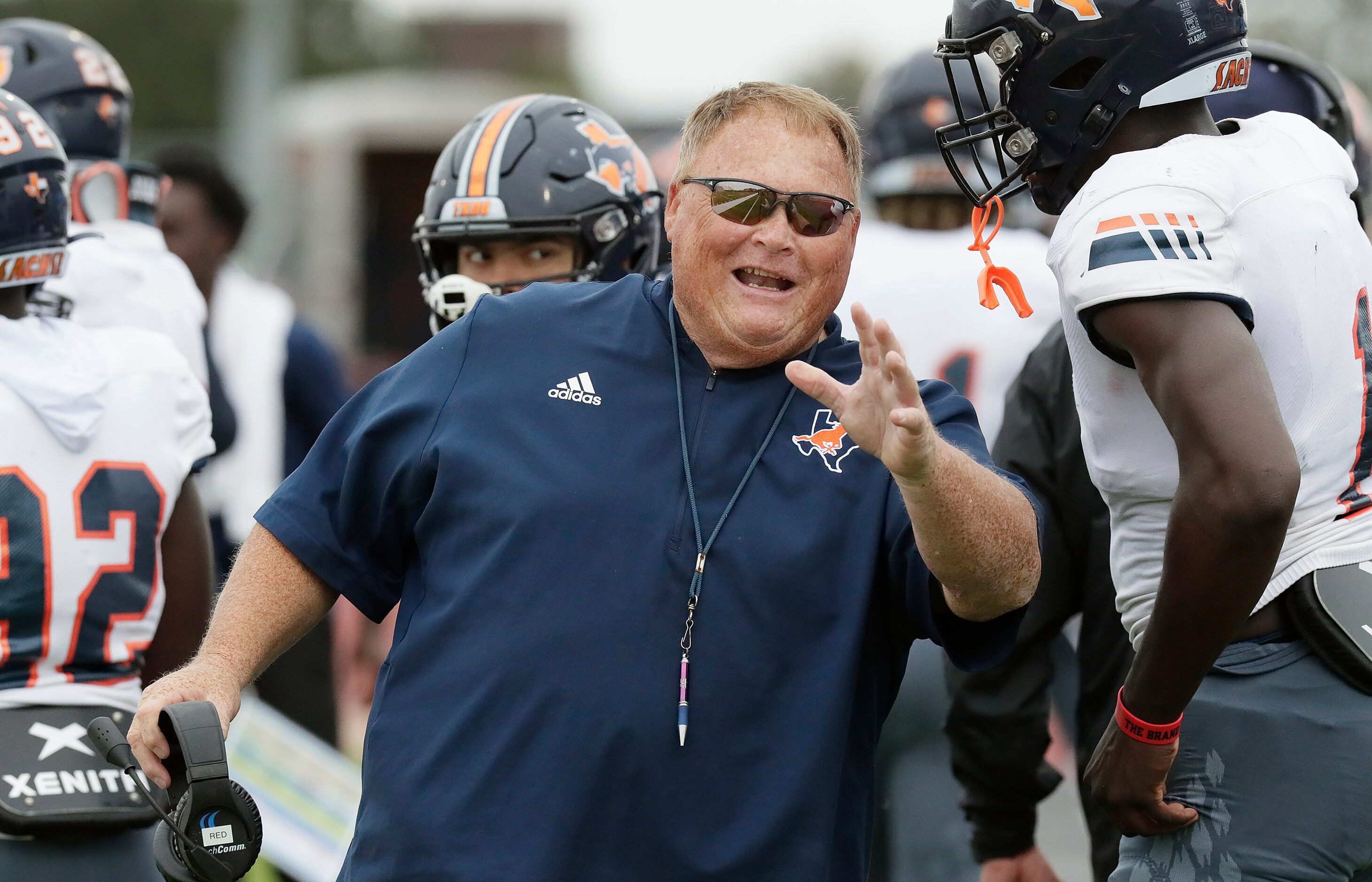 Sachse High School head coach Mark "Red" Behrens talks to his players after a defensive...