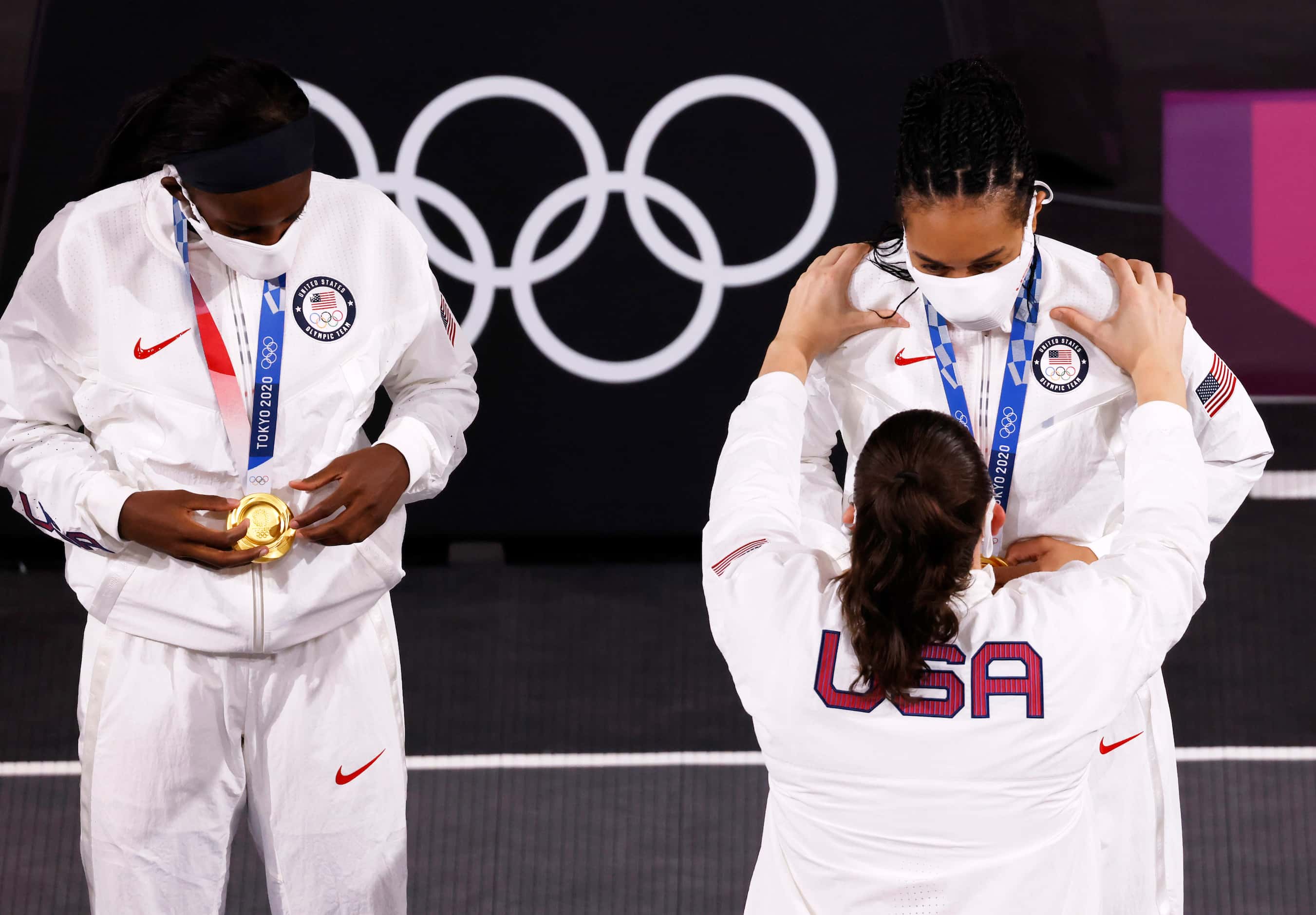 USA’s Stefanie Dolson (13) puts a gold medal on Allisha Gray (15) as Jacquelyn Young (8)...