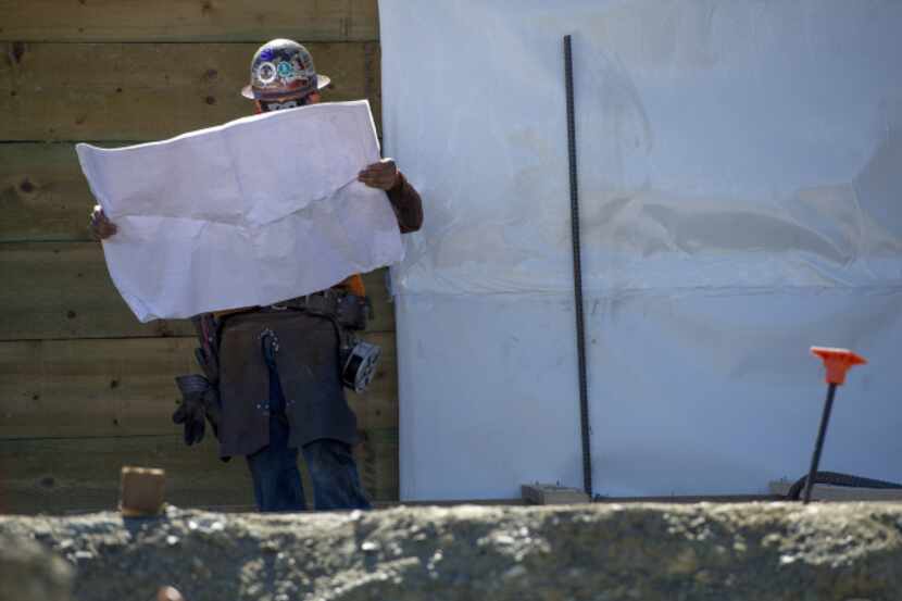 A contractor checks blueprint plans at Lennar Corp.'s The Shipyard housing project under...