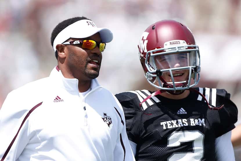 Head coach Kevin Sumlin of the Texas A&M Aggies chats with his quarterback Johnny Manziel #2...