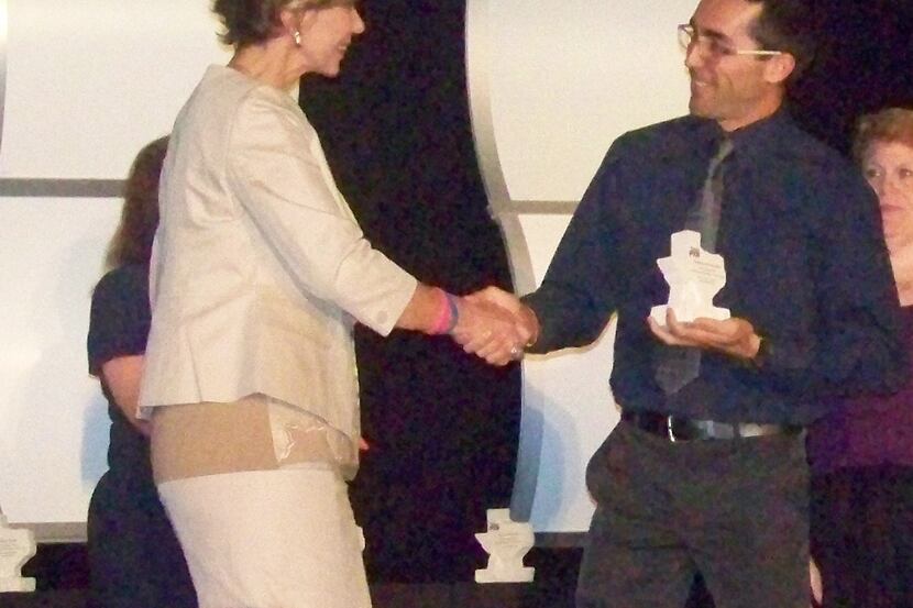 Forest Lane Academy teacher Oswaldo Rivera-Ortiz shakes hands with Texas PTA President,...