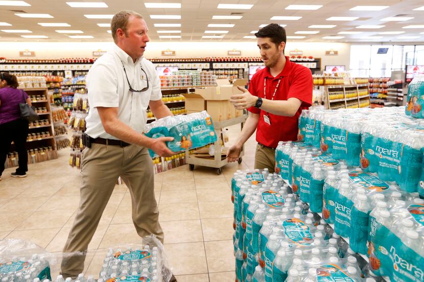 Buc-ee's store co-manager Tyler Campbell and Joshua Dziuban unload a pallet of bottled water...
