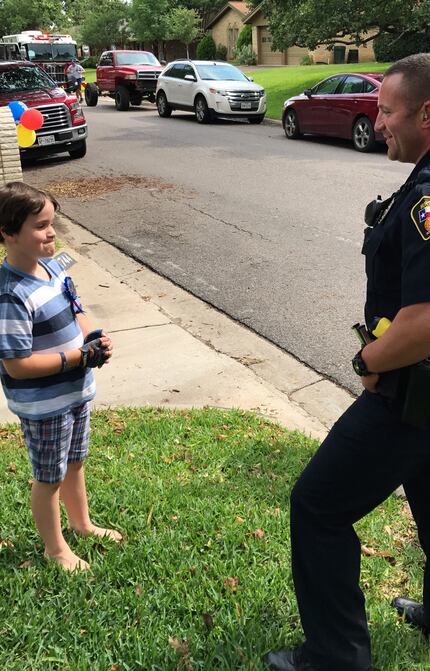 Graham Day, 8, talks with a Hurst police officer who celebrated his birthday with him.