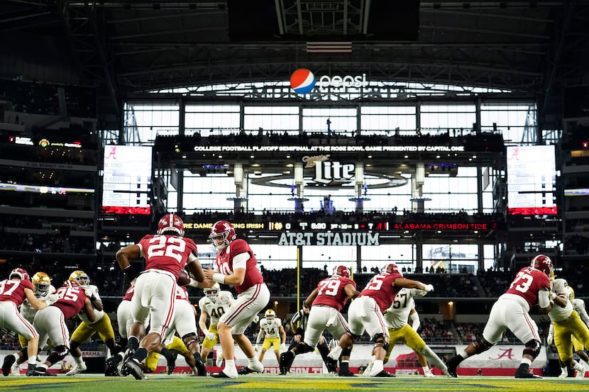 Alabama quarterback Mac Jones (10) hands off to running back Najee Harris (22) during the...