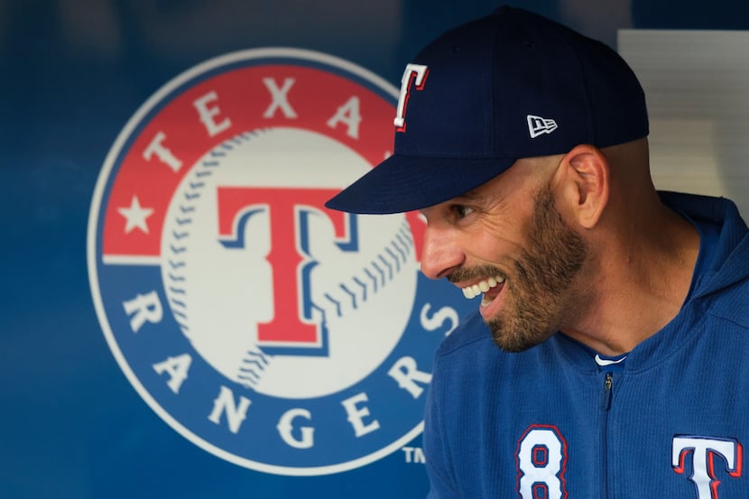 Texas Rangers manager Chris Woodward laughs in the dugout before a game against the Detroit...