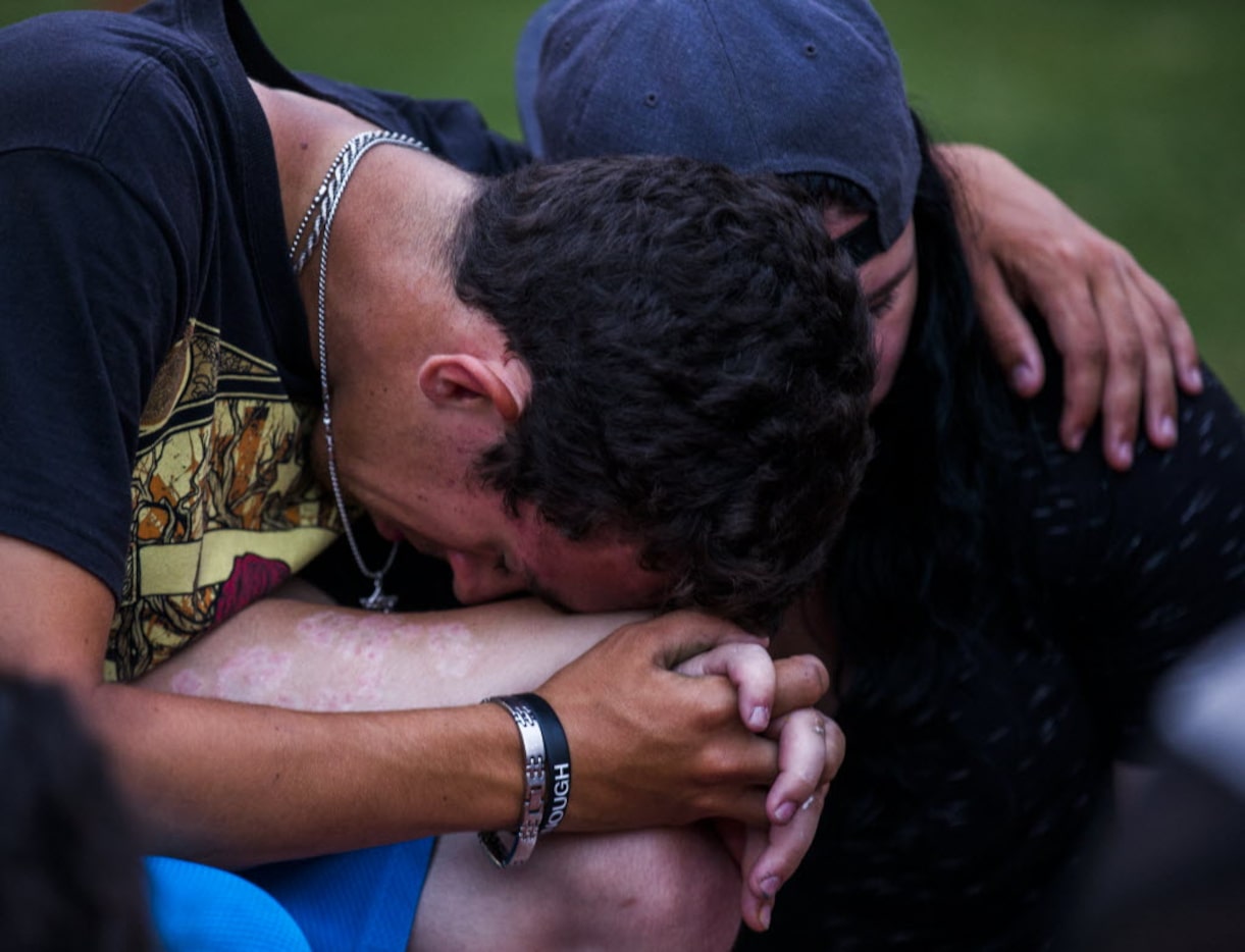 Jeffrey Sulman and Marion Wright pray together at Saturday's service at Klyde Warren Park....