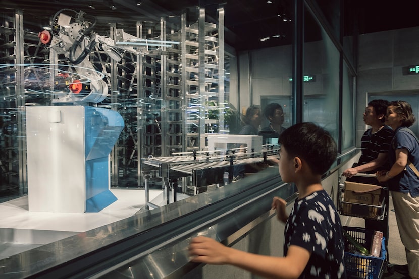 Customers watch robots take cooked food out onto a sort of runway that connects the kitchen...