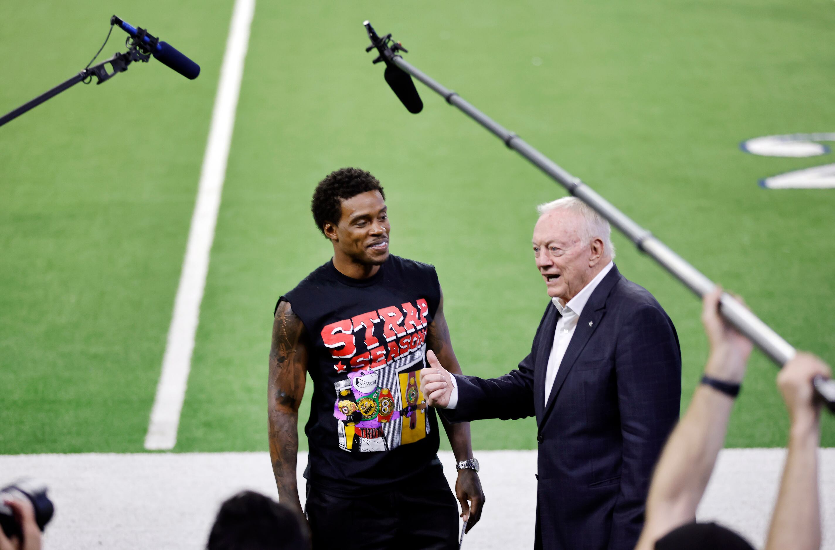 Dallas Cowboys owner Jerry Jones (right speaks to a film crew as he poses for photos with...