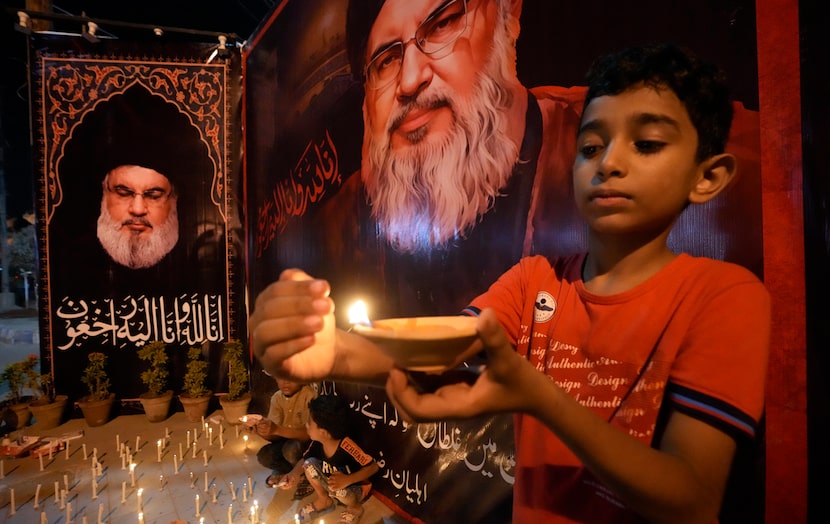 Shiite Muslims light candles during a protest against the killing of Hezbollah leader Hassan...