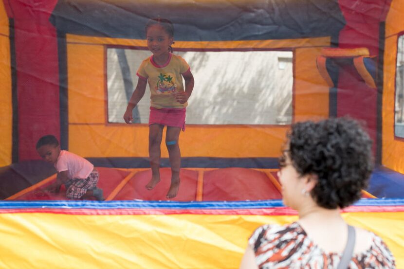 Delana Carter (right) watched her two kids, Nya (center), 3, and Myles, 2, play at a block...