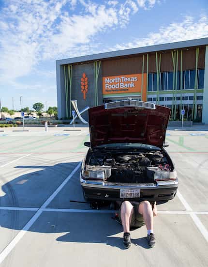 Elise Earnhart Bigony repairs her stalled car after donating food at North Texas Food Bank...