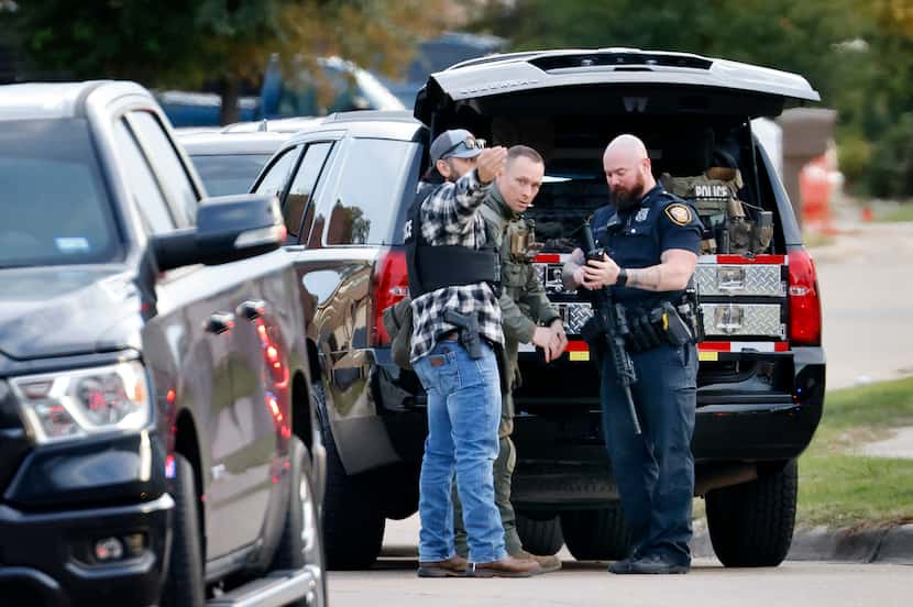 Fort Worth police officers huddled on Sheffield Place in Fort Worth before joining other...