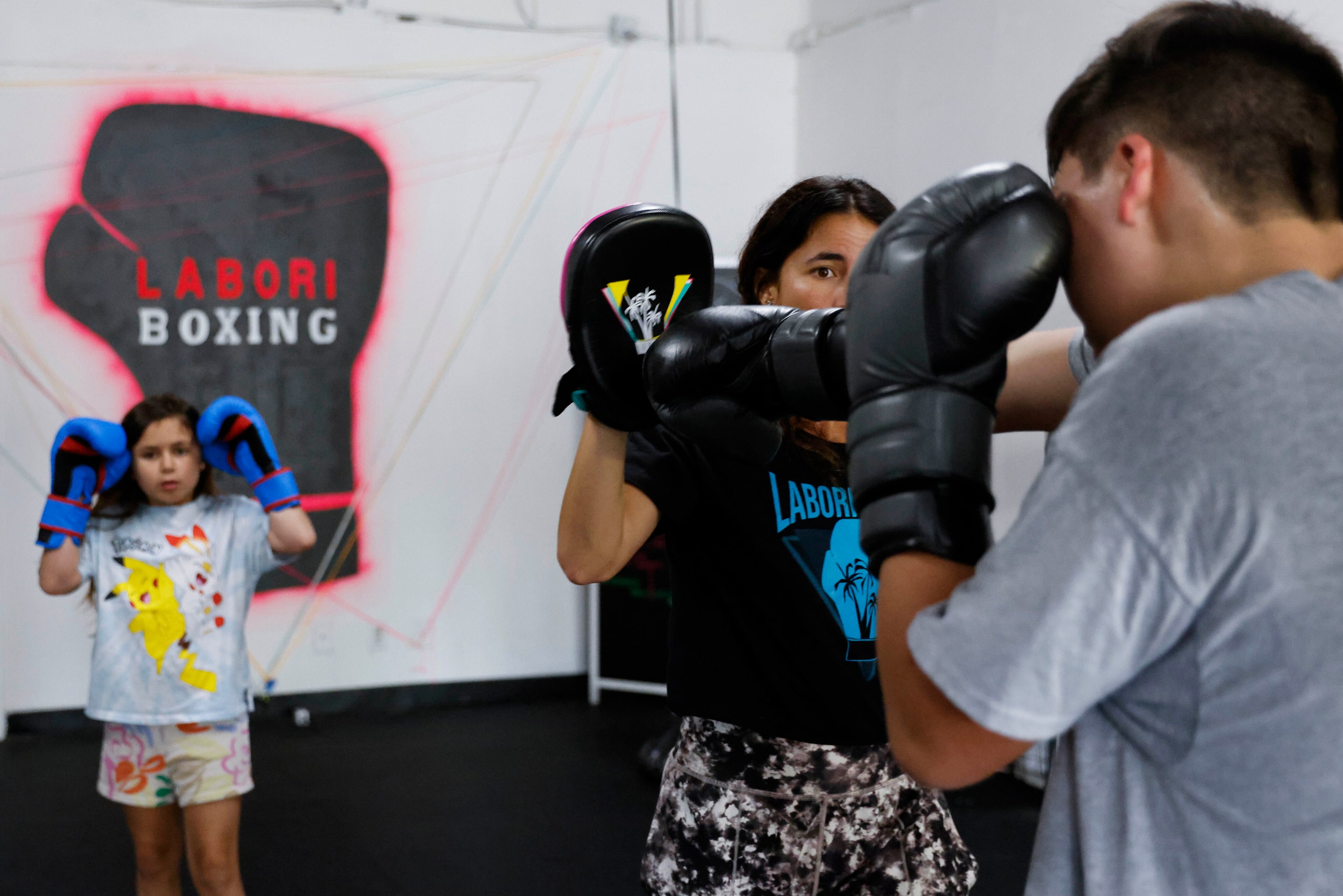 Amanda Alvarez, a salsa teacher and boxing lover, trains Eduardo Soto (right) as her...