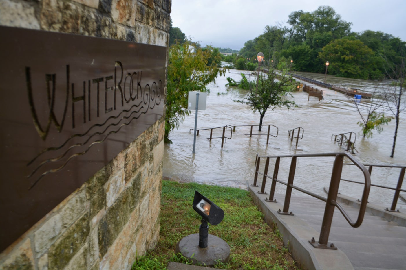 Water flooding out of the banks of White Rock Creek onto the Flagpole Hill Trail in Dallas...