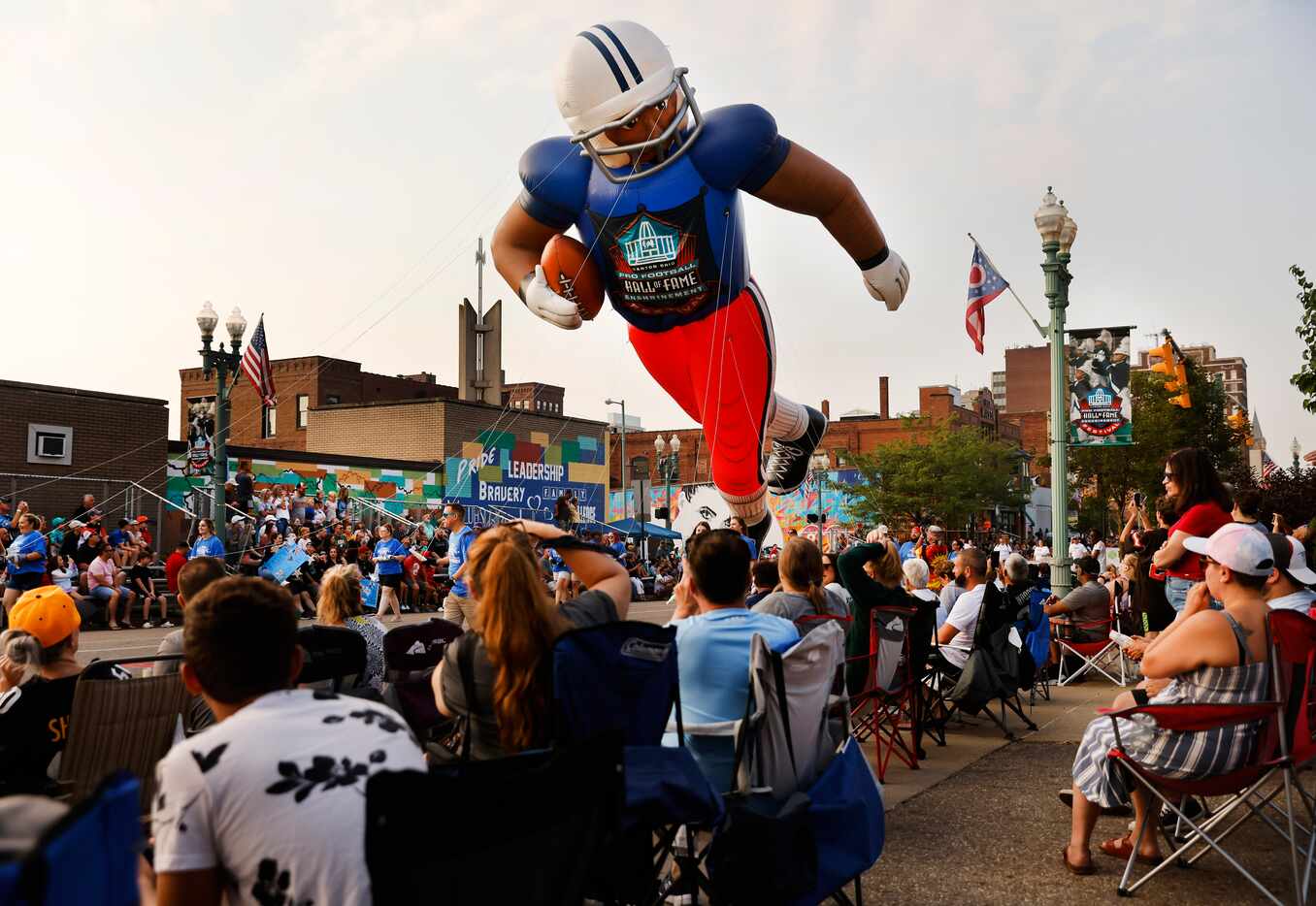 NFL fans watch as a large inflatable football player floats down Cleveland Ave. during the...