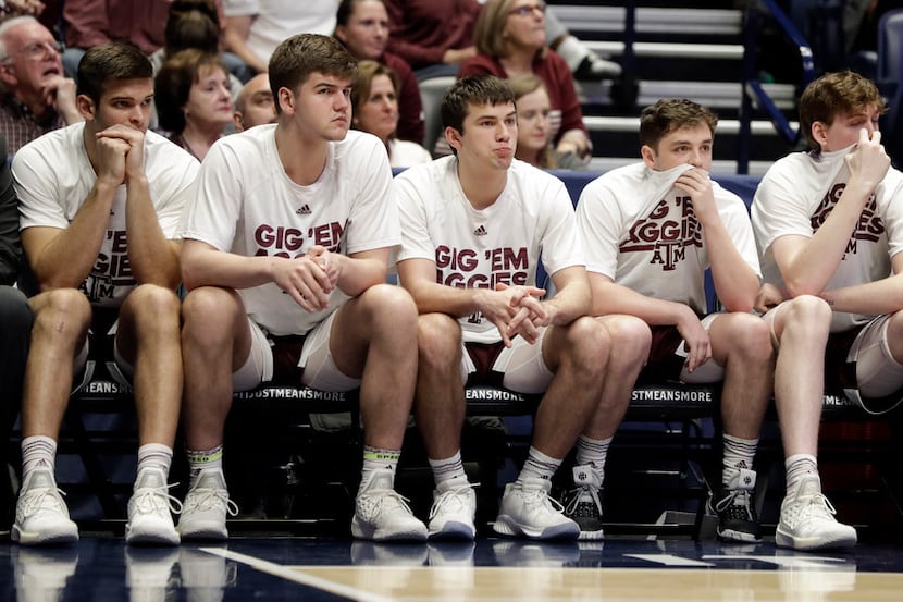 Texas A&M players watch from the bench in the final minutes of an NCAA college basketball...
