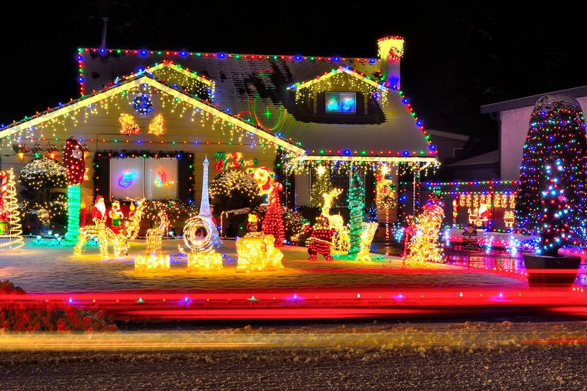 A beautiful display of Christmas lights brighten a dark snowy evening.