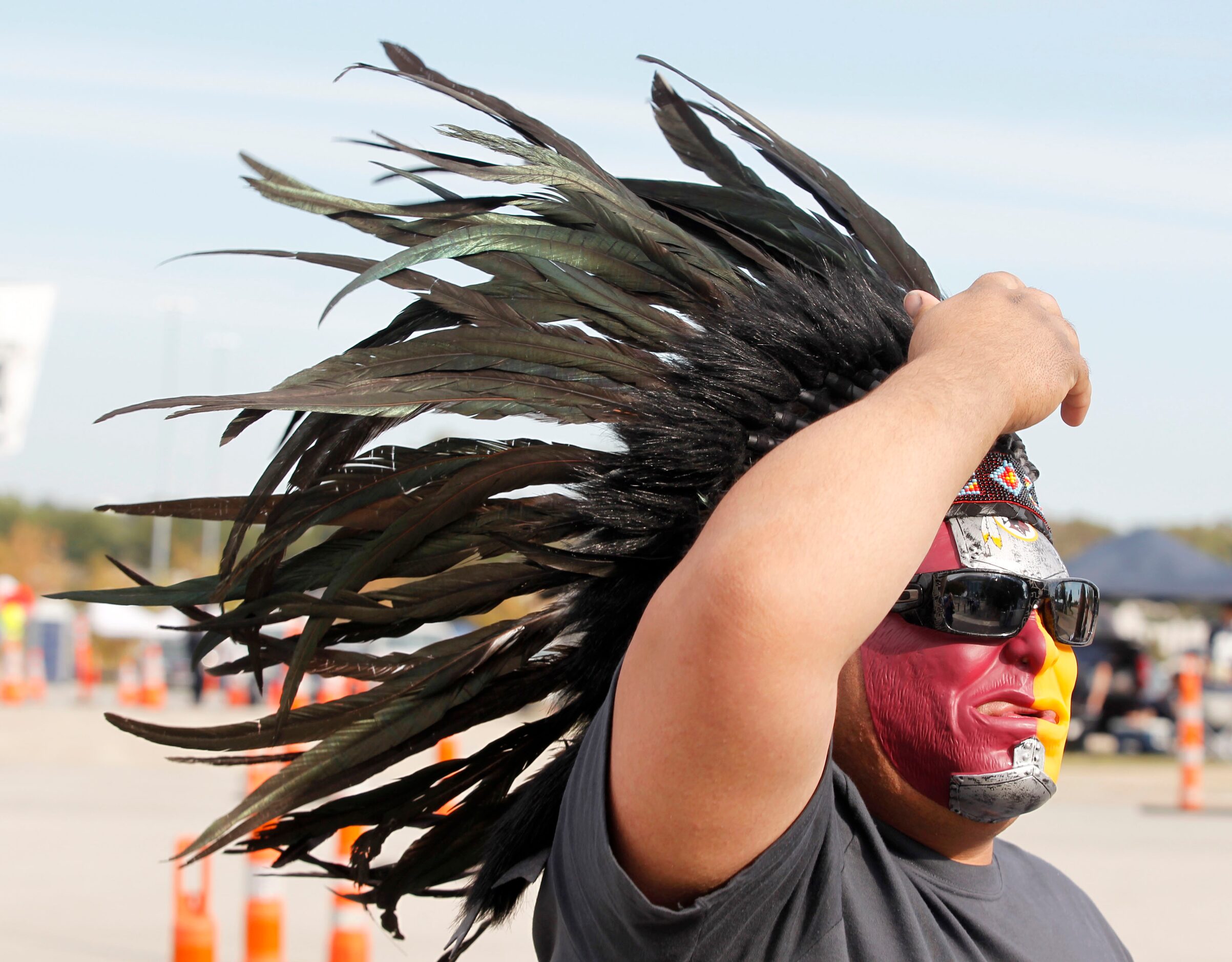 Washington Redskins fan Manuel Hernandez of Lubbock adjusts his feather headwear prior to...