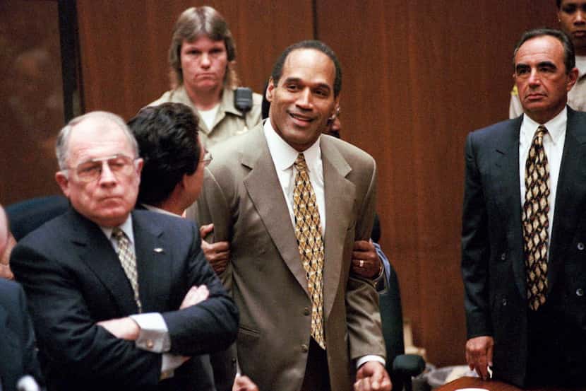 In this Oct. 3, 1995, file photo, O.J. Simpson, center, clenches his fists in victory after...