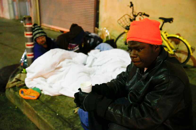 Dawaylon Raymond, 20, (right) drinks some donated coffee as Ryan Rule, 39, (left) and his...