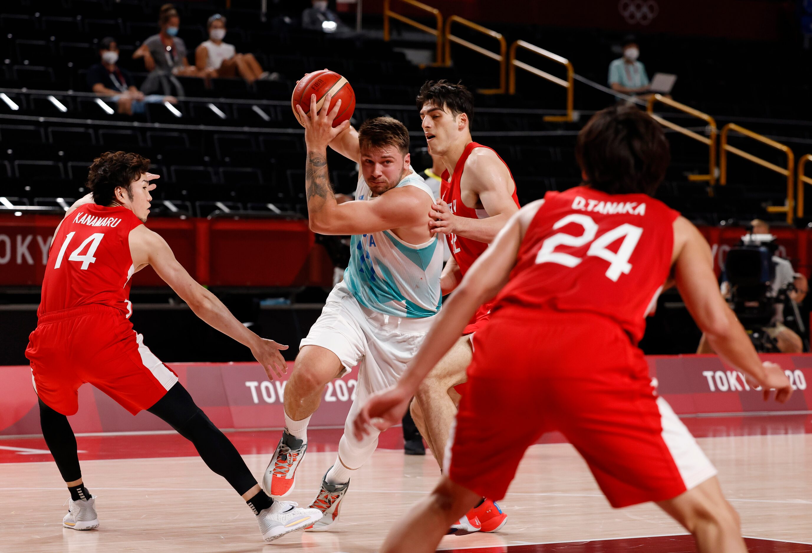 Slovenia’s Luka Doncic (77) splits Japan’s Kosuke Kanamaru (14) and Avi Koki Schafer (32) as...